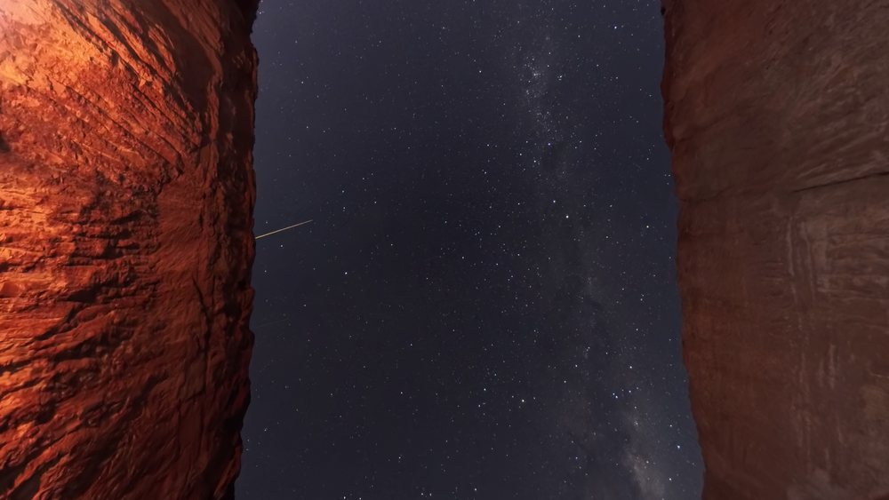 A streak crossing a star field above the mine wall.