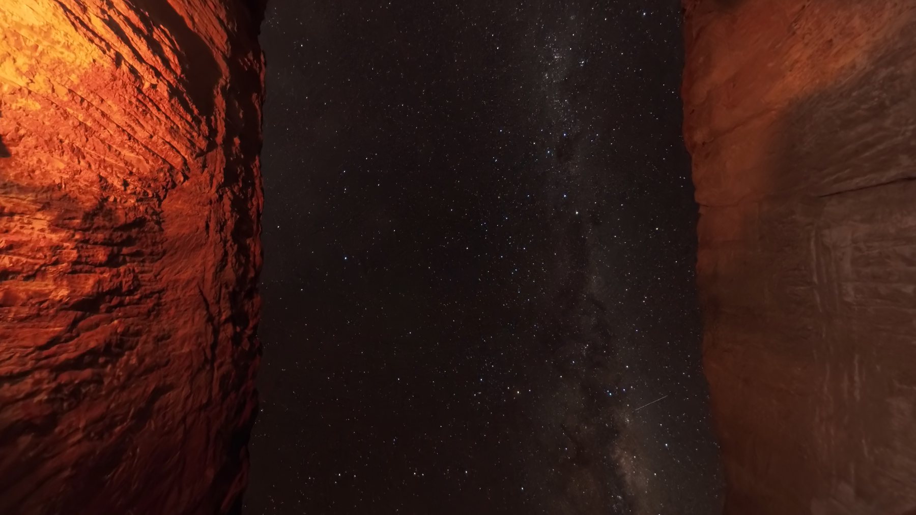 The Milky Way rising over the orange wall of an opal cut.