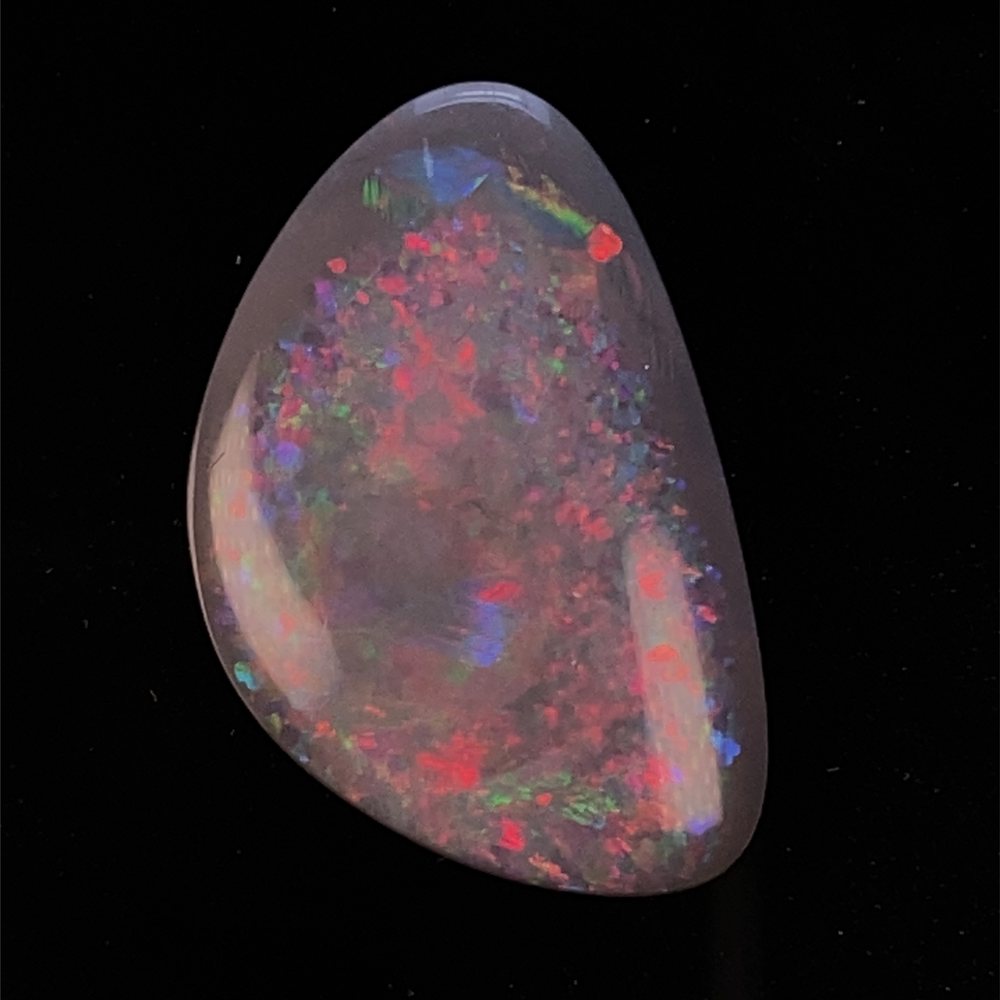 A dark-base freeform opal with pinfire colour.